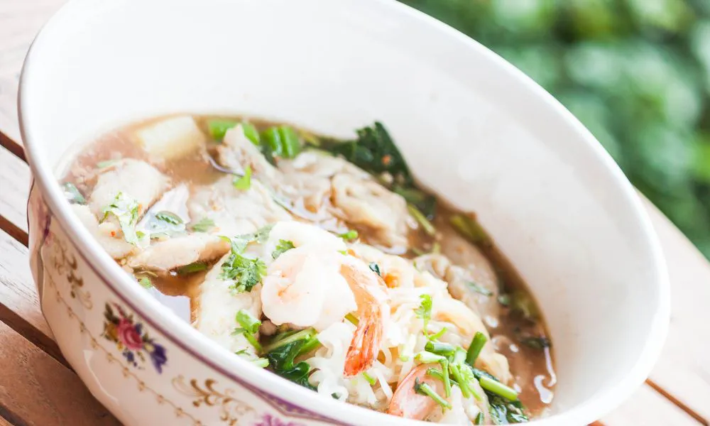 Seafood noodle soup with shrimp, herbs, and broth in a floral bowl at Saigon #1, a Vietnamese restaurant in Virginia Beach
