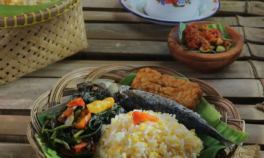 Traditional rice meal with fried fish, vegetables, and tempeh in a basket at Saigon #1, a Vietnamese restaurant in Virginia Beach